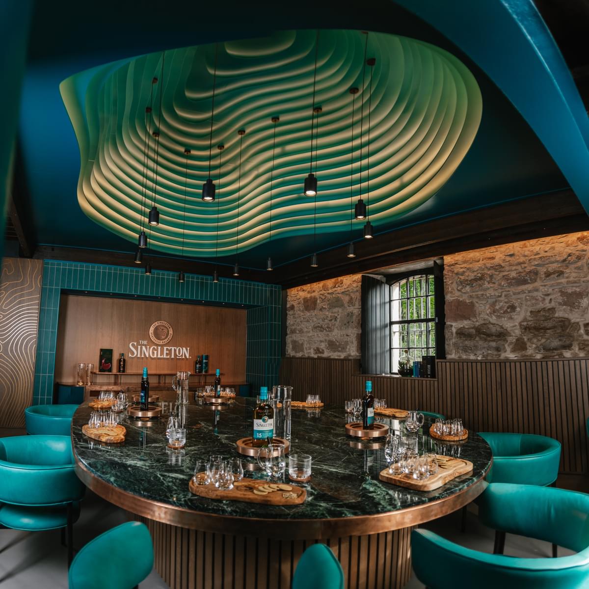 The Singleton of Glen Ord tasting room, with tasting glasses set around a table beneath a sculpted ceiling